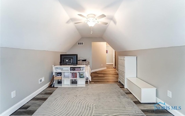 additional living space featuring dark wood-style flooring, visible vents, and baseboards