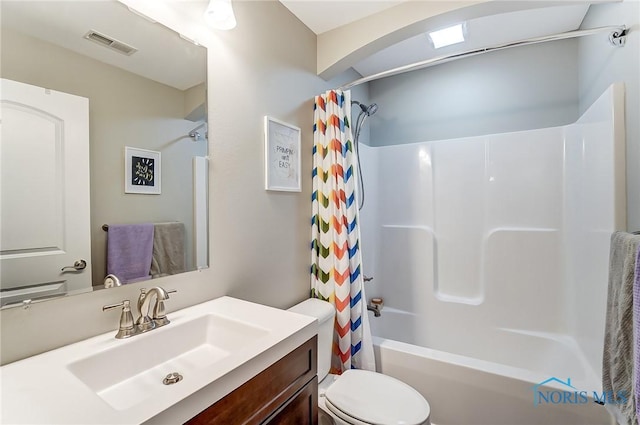 bathroom featuring visible vents, vanity, toilet, and shower / bath combo with shower curtain