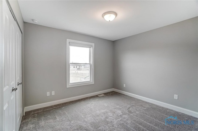 carpeted empty room with baseboards