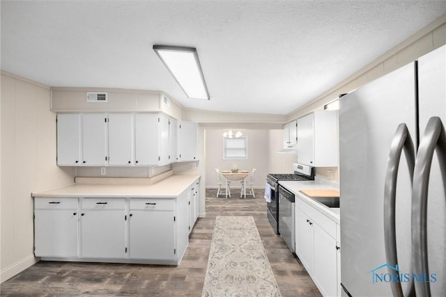 kitchen featuring dark wood-style flooring, light countertops, visible vents, appliances with stainless steel finishes, and white cabinets