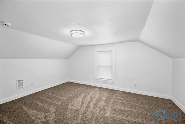 bonus room featuring lofted ceiling, carpet, baseboards, and visible vents