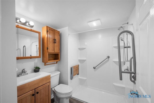 bathroom featuring toilet, a shower, and vanity