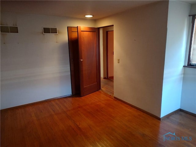 unfurnished bedroom featuring light wood-style floors, visible vents, and baseboards