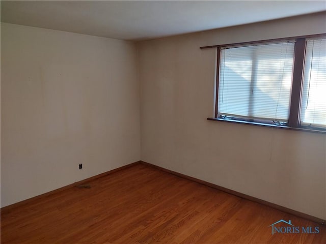 empty room featuring light wood-style flooring and baseboards