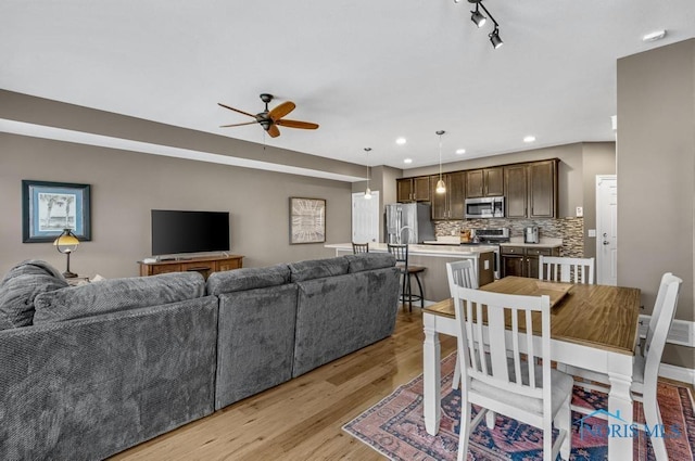 dining room with light wood-type flooring, ceiling fan, and recessed lighting