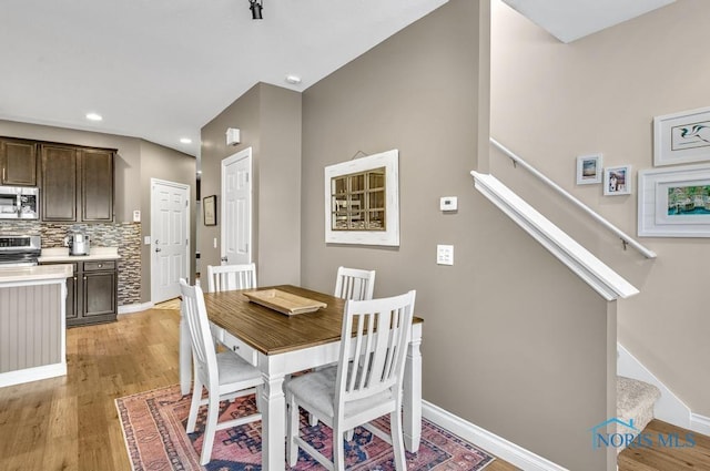 dining space with light wood finished floors, stairway, recessed lighting, and baseboards