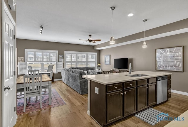 kitchen with dark brown cabinetry, a sink, light countertops, light wood-type flooring, and dishwasher