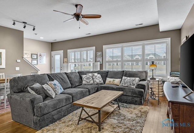 living area featuring visible vents, ceiling fan, track lighting, and wood finished floors