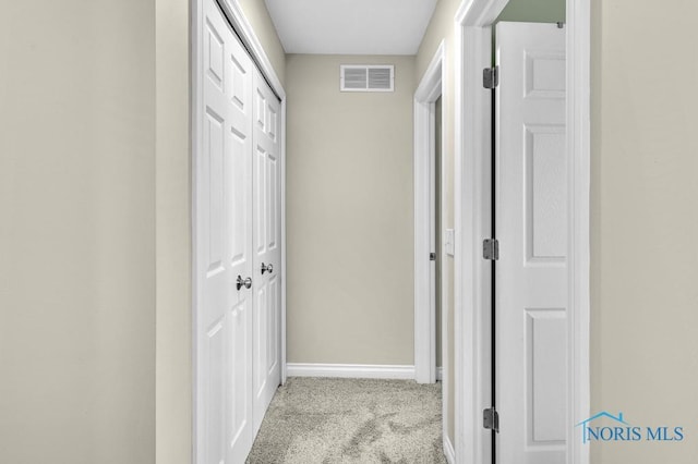 hall featuring baseboards, visible vents, and carpet flooring