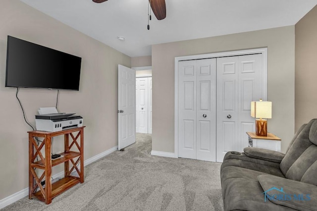 living room with ceiling fan, baseboards, and light colored carpet