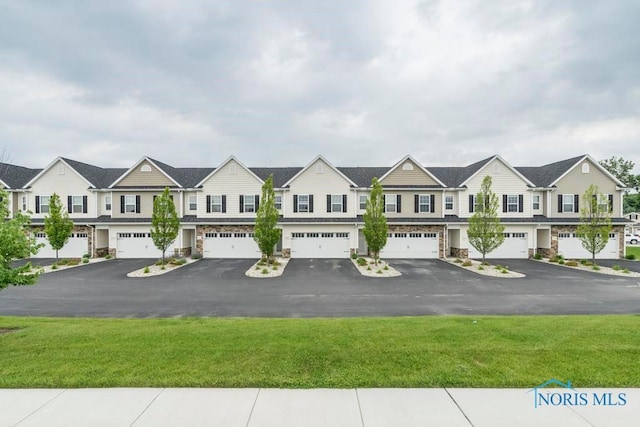 view of front of home featuring driveway, an attached garage, and a residential view