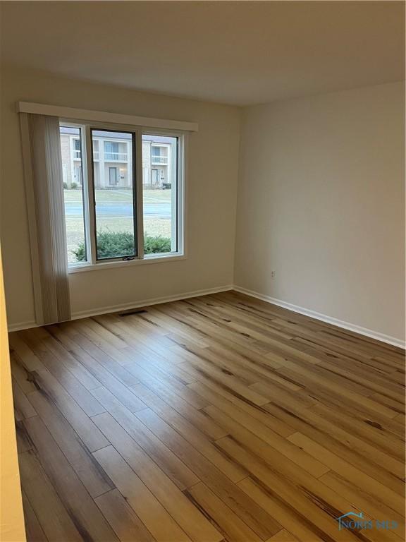 spare room with wood finished floors and baseboards