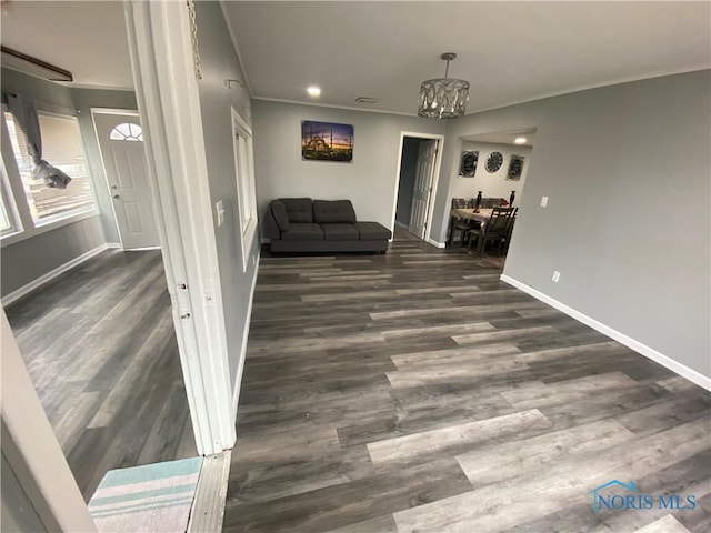 unfurnished living room featuring baseboards, ornamental molding, wood finished floors, a chandelier, and recessed lighting