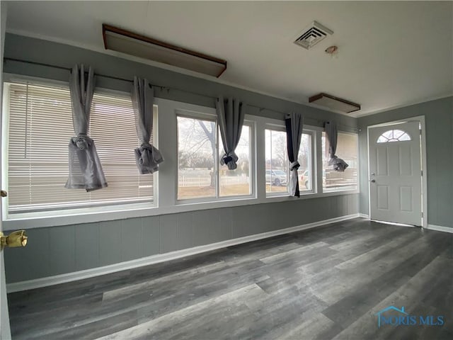 foyer entrance featuring baseboards, visible vents, and wood finished floors