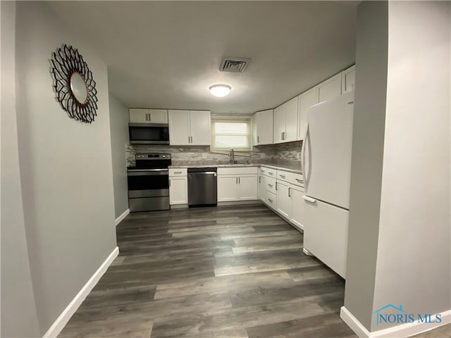 kitchen featuring a sink, visible vents, white cabinets, appliances with stainless steel finishes, and backsplash