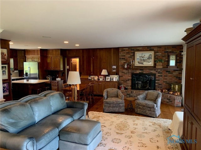 living area featuring recessed lighting, a fireplace, and wood finished floors