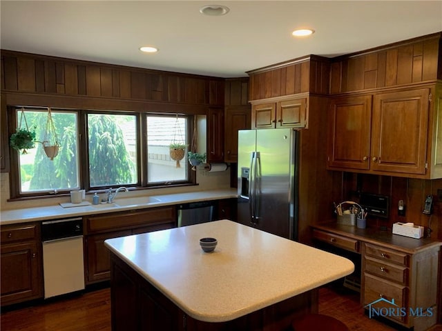 kitchen with appliances with stainless steel finishes, light countertops, and a sink