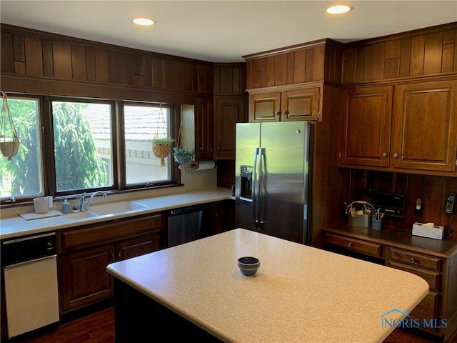 kitchen featuring stainless steel fridge, dishwasher, light countertops, a sink, and recessed lighting