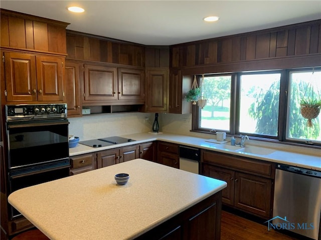 kitchen featuring black appliances, light countertops, a sink, and recessed lighting