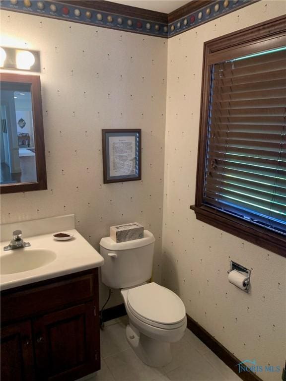 bathroom featuring tile patterned flooring, baseboards, vanity, and toilet