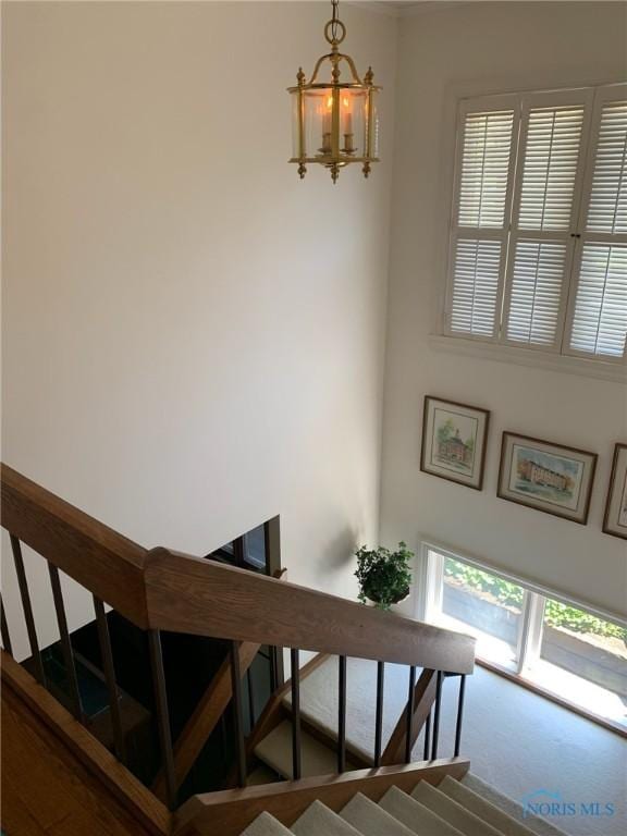 stairway featuring carpet floors and an inviting chandelier