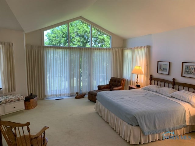 bedroom with light colored carpet, vaulted ceiling, and visible vents