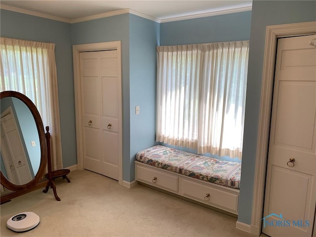 bedroom featuring light colored carpet, crown molding, and baseboards