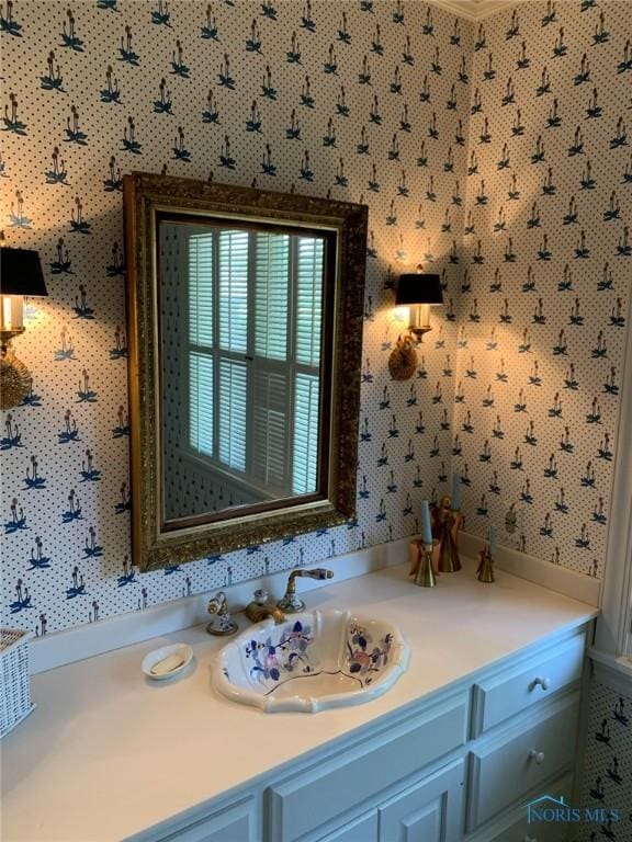 bathroom featuring vanity and wallpapered walls