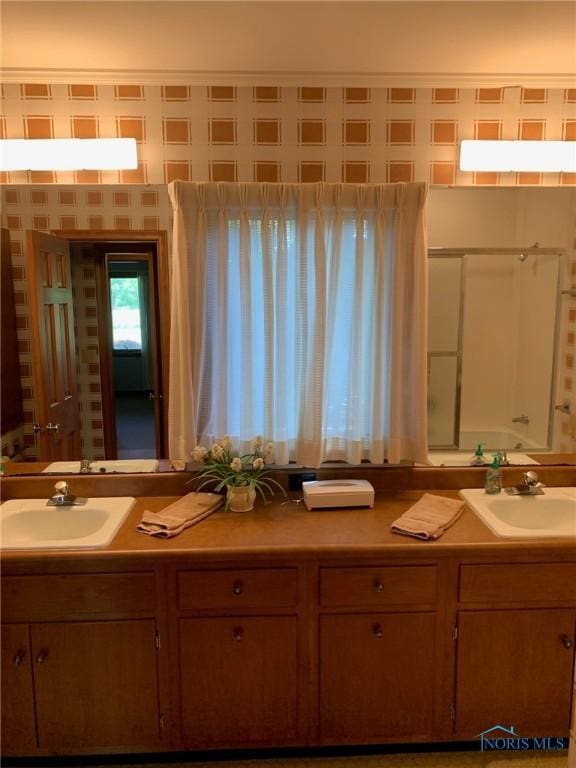 full bath featuring double vanity, a sink, and wallpapered walls