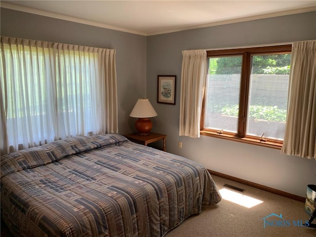 carpeted bedroom with ornamental molding, visible vents, and baseboards