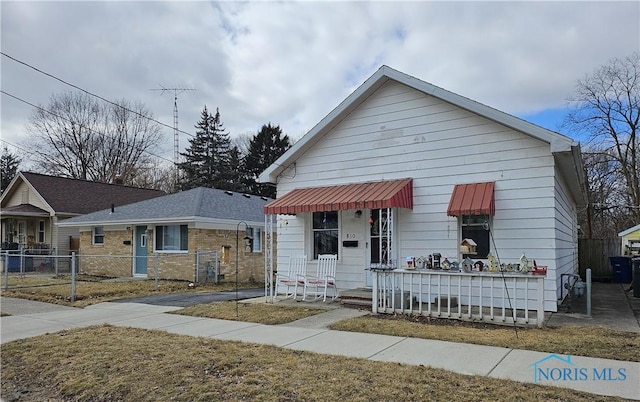 bungalow-style house with a porch and fence