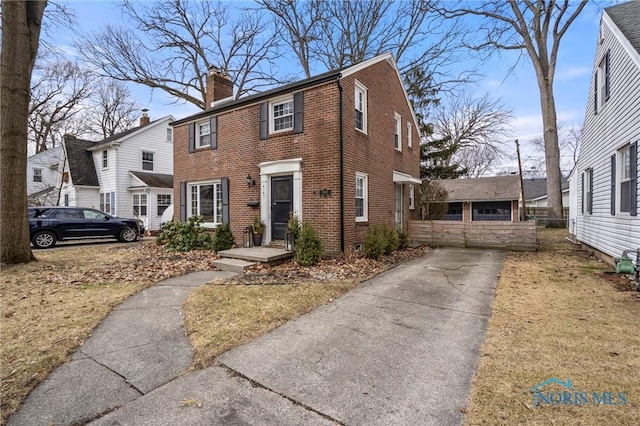 view of front of home with brick siding and a chimney