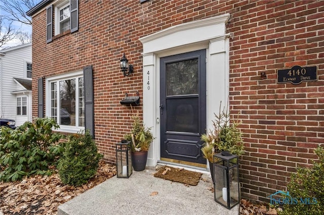 doorway to property with brick siding