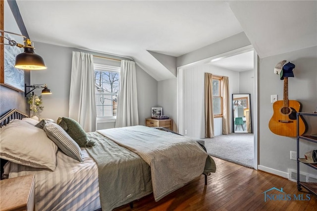 bedroom with wood finished floors, visible vents, and baseboards