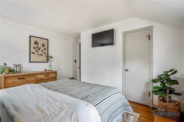 bedroom with vaulted ceiling and wood finished floors