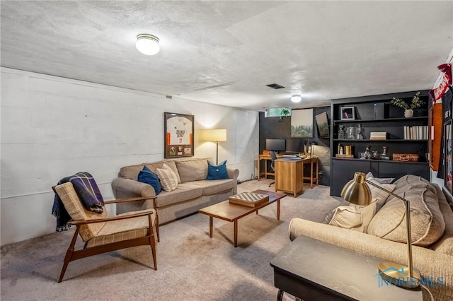 living room with concrete block wall, carpet flooring, visible vents, and a textured ceiling