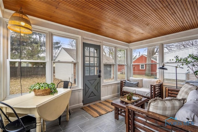 sunroom / solarium featuring a wealth of natural light and wooden ceiling