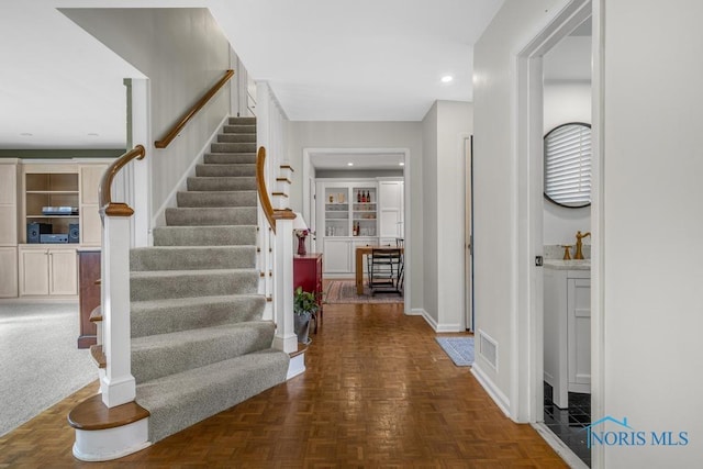 foyer entrance with stairs, baseboards, visible vents, and recessed lighting