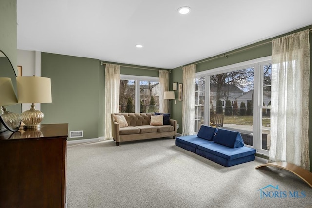 living area featuring carpet floors, baseboards, visible vents, and recessed lighting