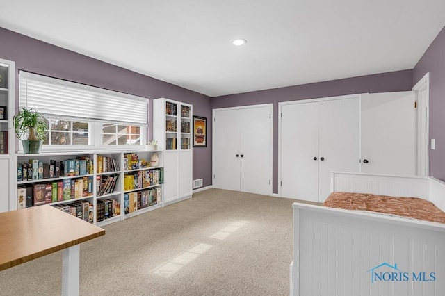 bedroom featuring light carpet, visible vents, two closets, and recessed lighting