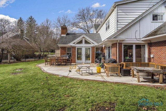 rear view of property with a patio, brick siding, fence, and french doors