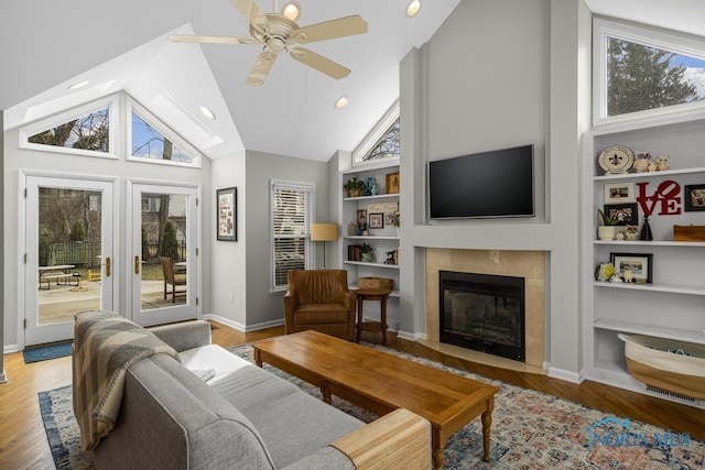 interior space featuring wood finished floors, a fireplace with flush hearth, and built in features