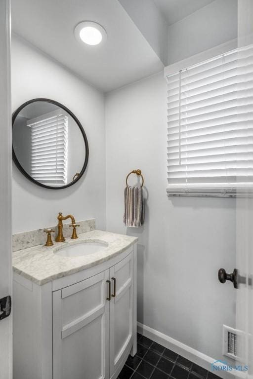 bathroom with tile patterned flooring, vanity, visible vents, and baseboards