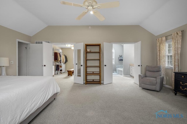 bedroom with vaulted ceiling, a spacious closet, carpet flooring, and ensuite bathroom