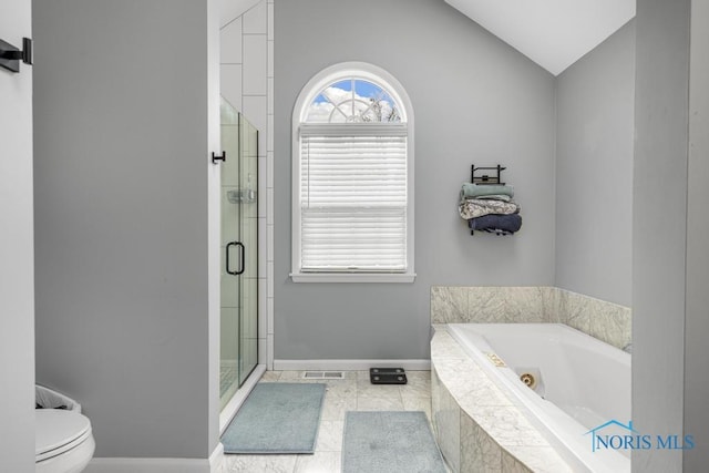 full bathroom with toilet, vaulted ceiling, a shower stall, a jetted tub, and baseboards