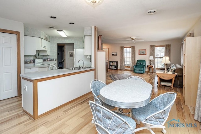 dining room with ceiling fan, light wood-type flooring, and visible vents