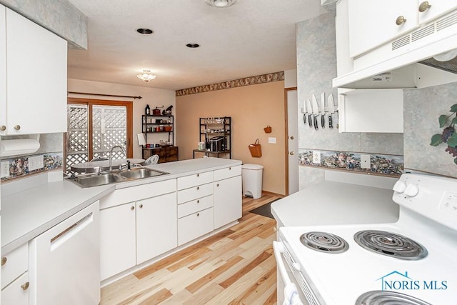 kitchen with light countertops, white cabinetry, a sink, white appliances, and under cabinet range hood