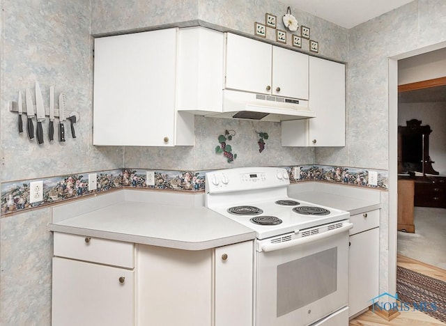 kitchen with white cabinets, under cabinet range hood, light countertops, and white electric range