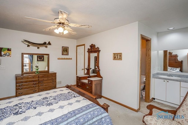 bedroom with a textured ceiling, light carpet, a sink, a ceiling fan, and baseboards