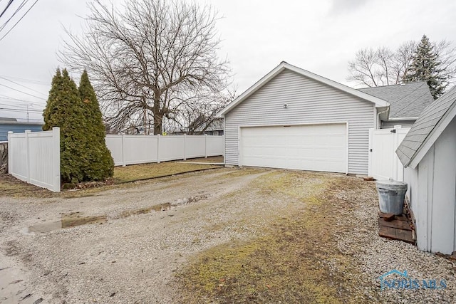 garage with driveway and fence